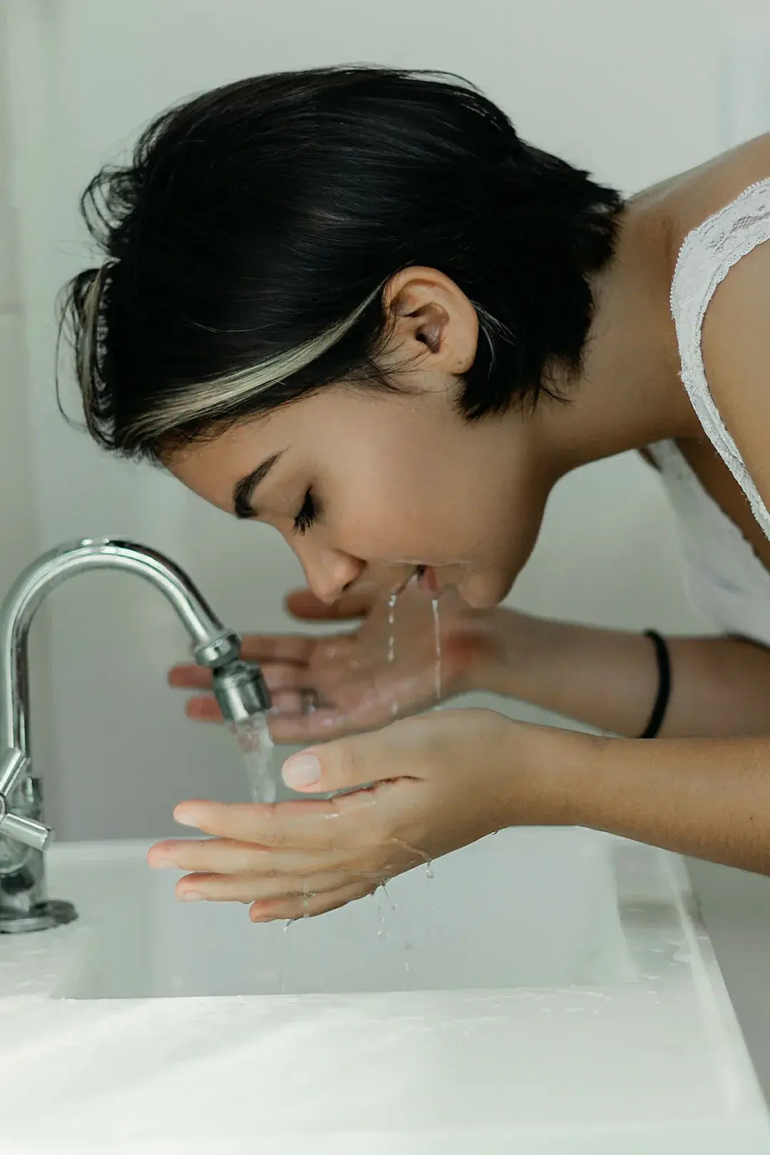 Woman cleaning her face with water