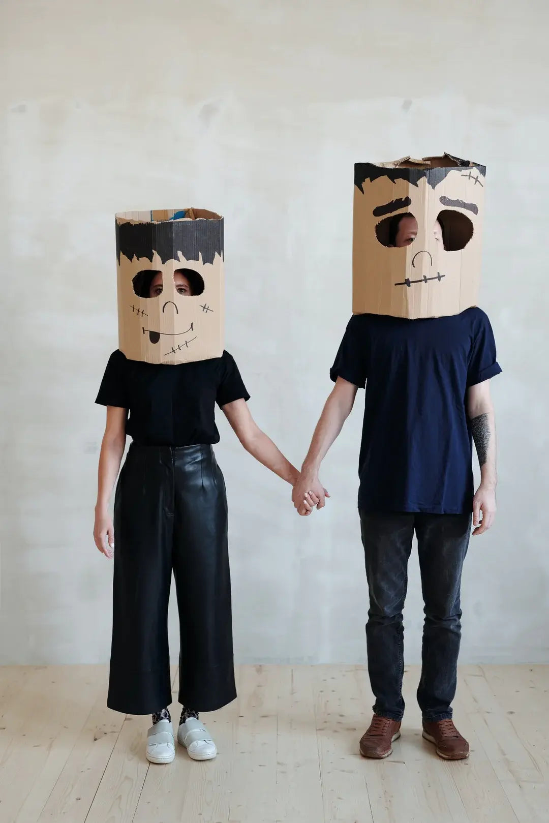 two people wearing cardboard masks