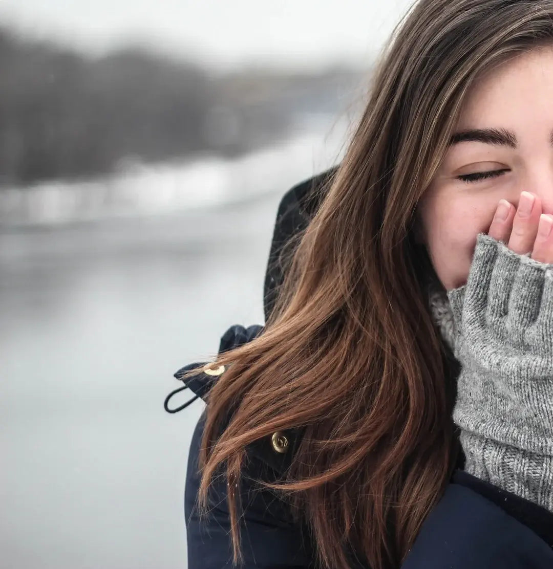 woman with her hands over her mouth for warmth
